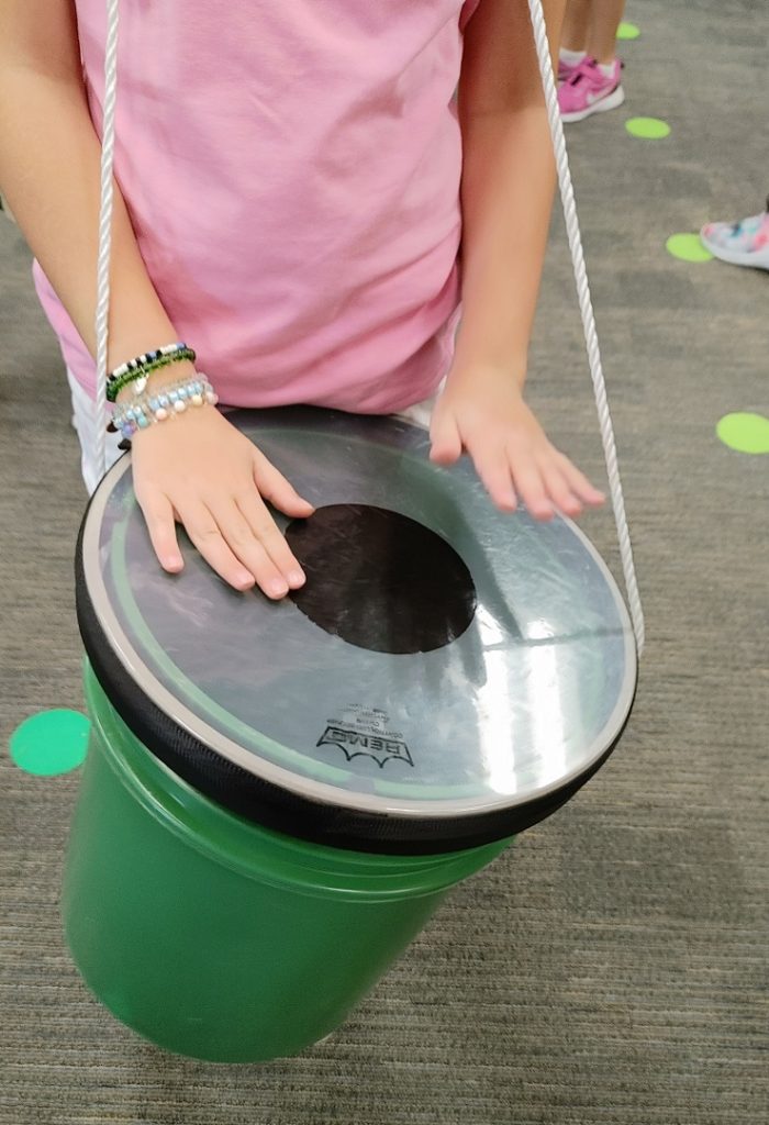 female student playing a bucket drum