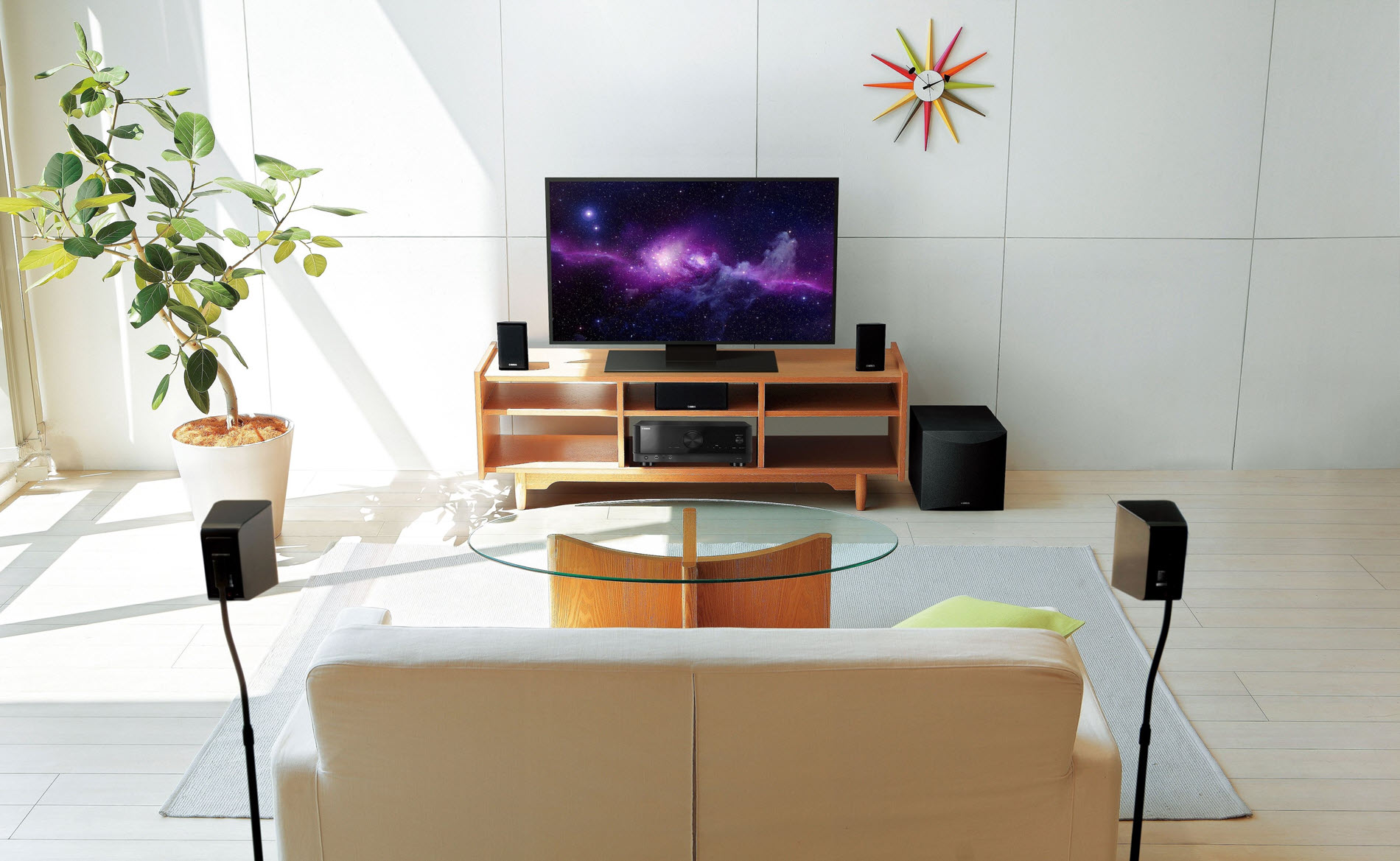 Modern living room with TV and surround sound units.