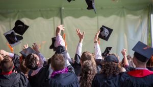 students throwing graduation caps in the air