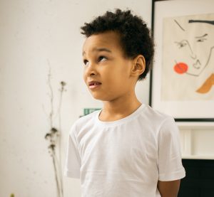 young boy looking sheepish after getting caught doing something wrong