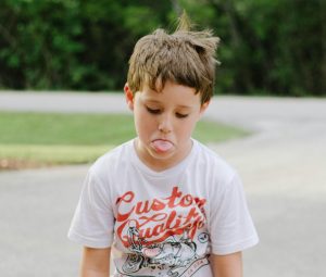 frustrated boy sticking his tongue out 