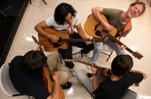 happy group of four guitarists