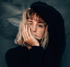 female teen with hands on her face and head