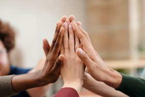 close up of four hands doing a group high five