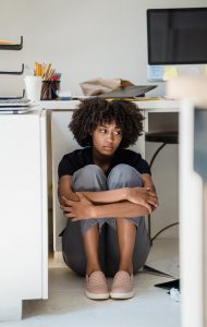 woman sitting on floor with knees up looking forlorn