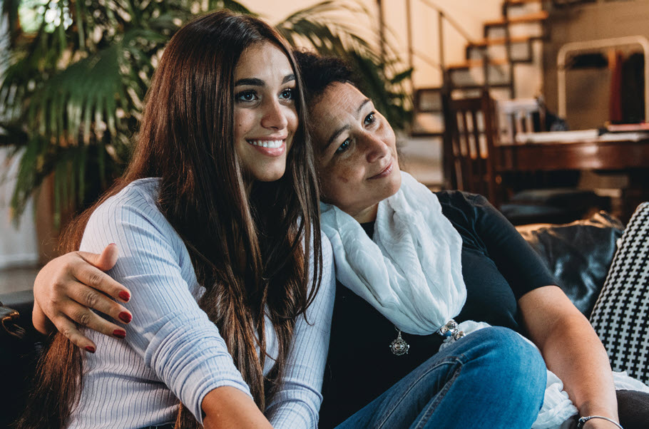 Mother and daughter sitting shoulder to shoulder.