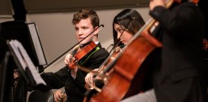 two violin players performing