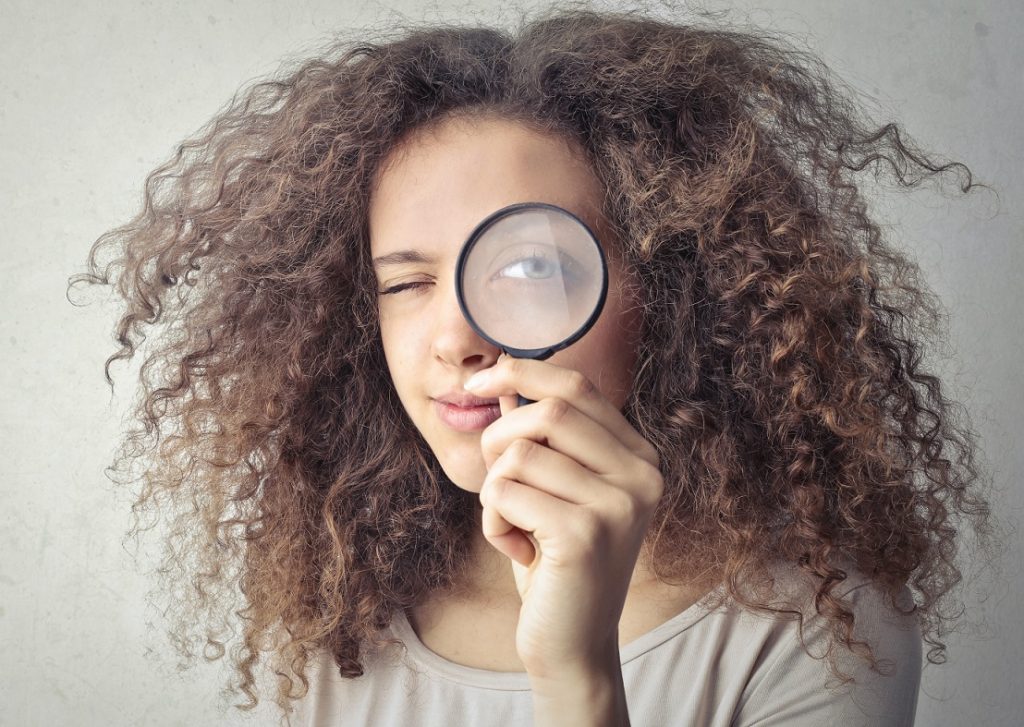 woman looking through a magnifying glass