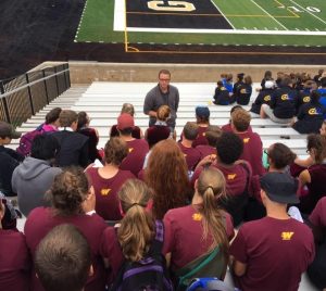 Dylan Sims talking to band members in football stands