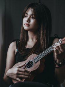 middle school female playing the ukulele