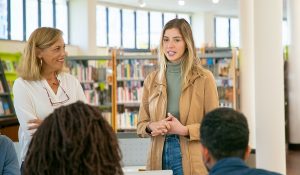 teacher looking on for a student presentation