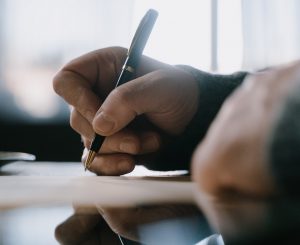 close up of hands writing note