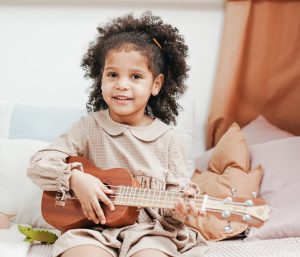 elementary school female student holding the ukulele