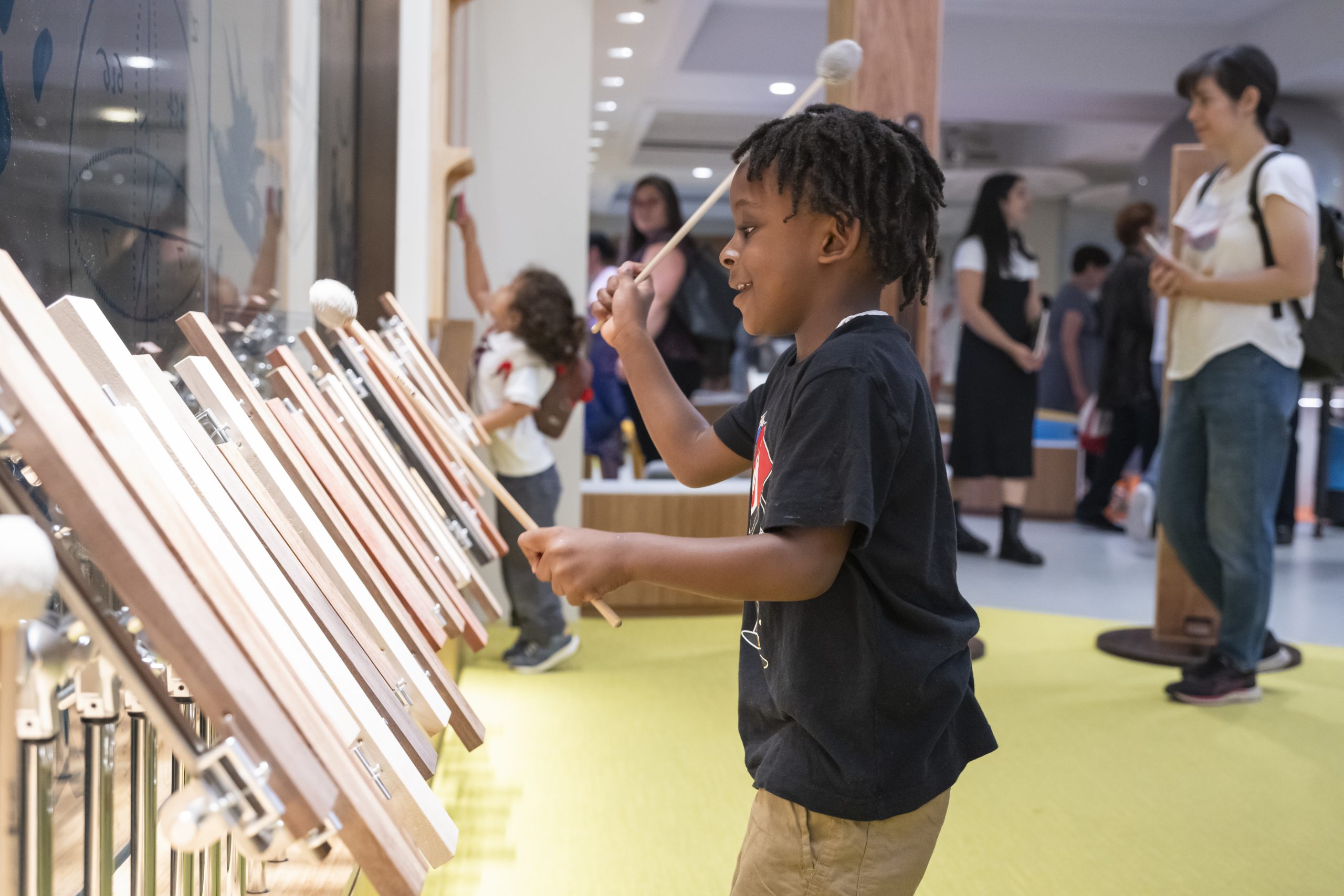 81SS-Marimba-2-scaled Young child playing a percussion instrument.