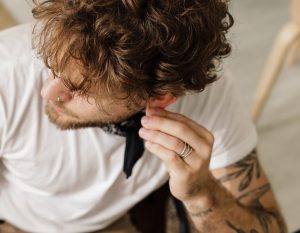 man rubbing ear