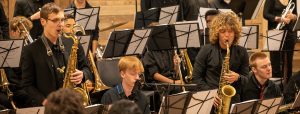 jazz band with two saxophone players standing and performing