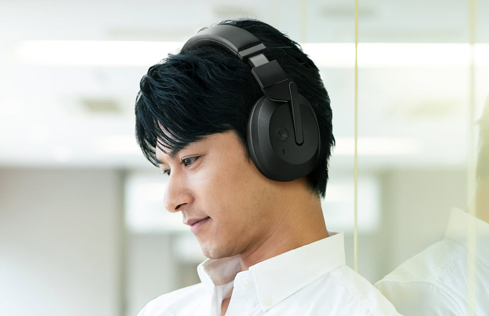 YHE700B_BL_man-left-side-resize Man seen in profile wearing over head headphones.