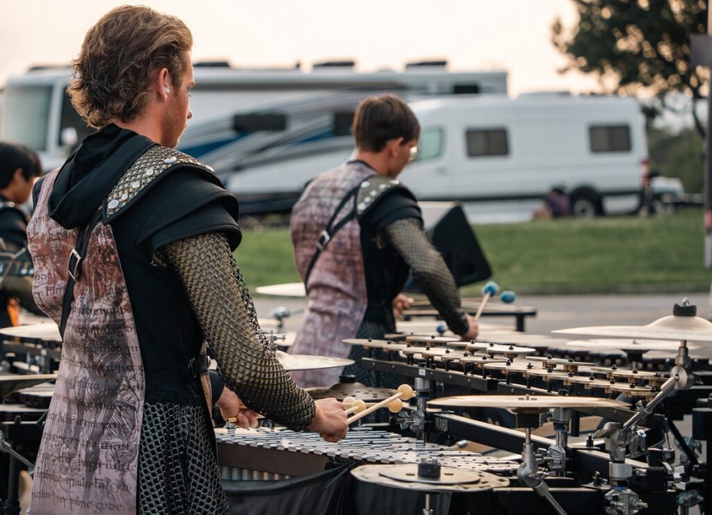 drum corps members playing on mounted mallet instruments