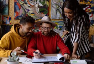 three people looking at paper and smiling