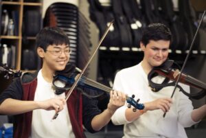 orchestra rehearsal with two students playing silent violins