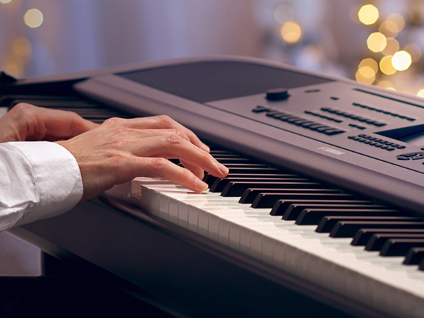 BRDADM792900-Holiday-2023-Blog-Images_dgx_600x450 Closeup of someone's hands playing electric piano.