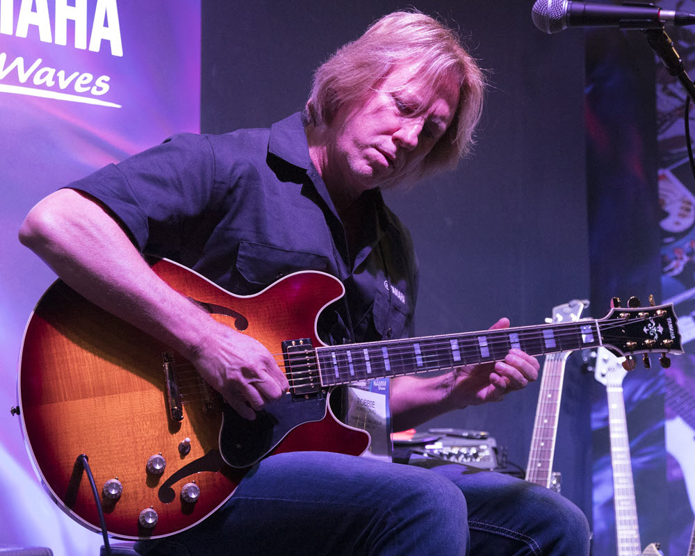 Author playing guitar at event.