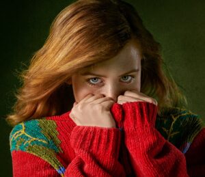 shy girl hiding behind her hands