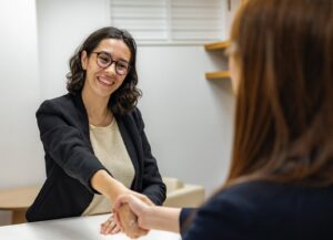 two women shaking hands and showing professionalism