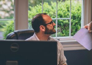 teacher sitting at desk being interrupted 