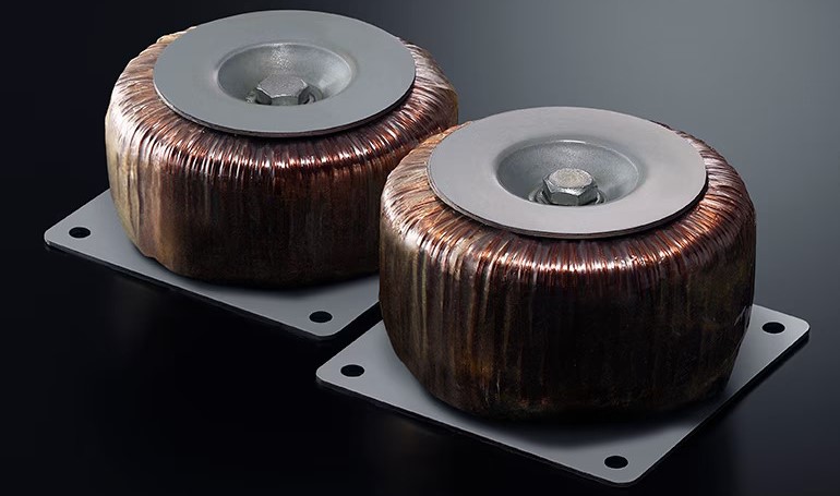 HAL7A_ToroidalTransformers_6854576e5e60128dbf1361a7852e50d4 Two small transformers wrapped in copper wire.