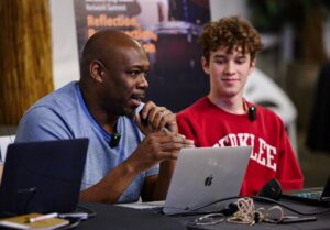 instructor and student speaking at a panel