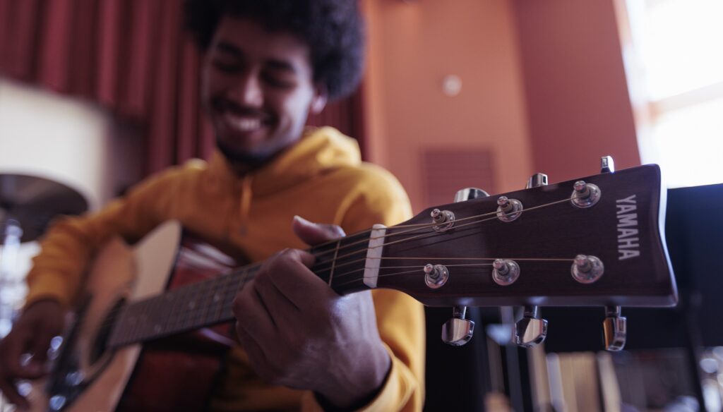 student playing guitar in class