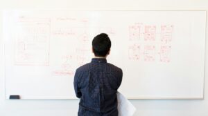 man studying what's written on white board