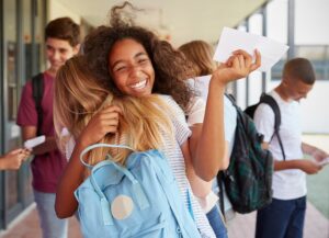two females celebrating and hugging at school