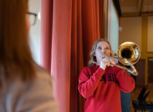 teacher in foreground while student plays trombone