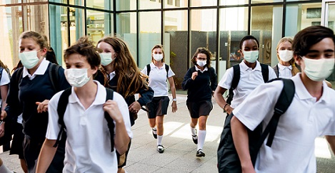 students wearing masks while walking in school hallway