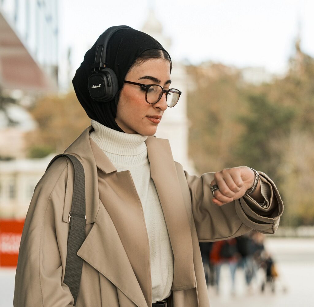 woman standing outside and looking at watch