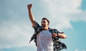 overly exuberant man holding one fist in the air