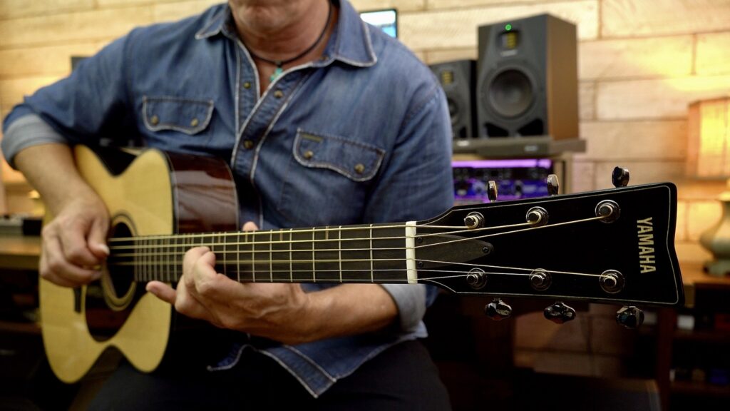 person playing acoustic guitar