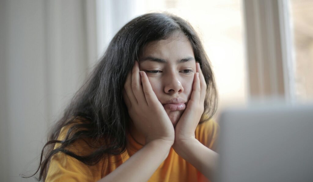 student looking bored with face in both hands