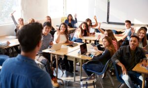 engaged students raising hands in classroom 