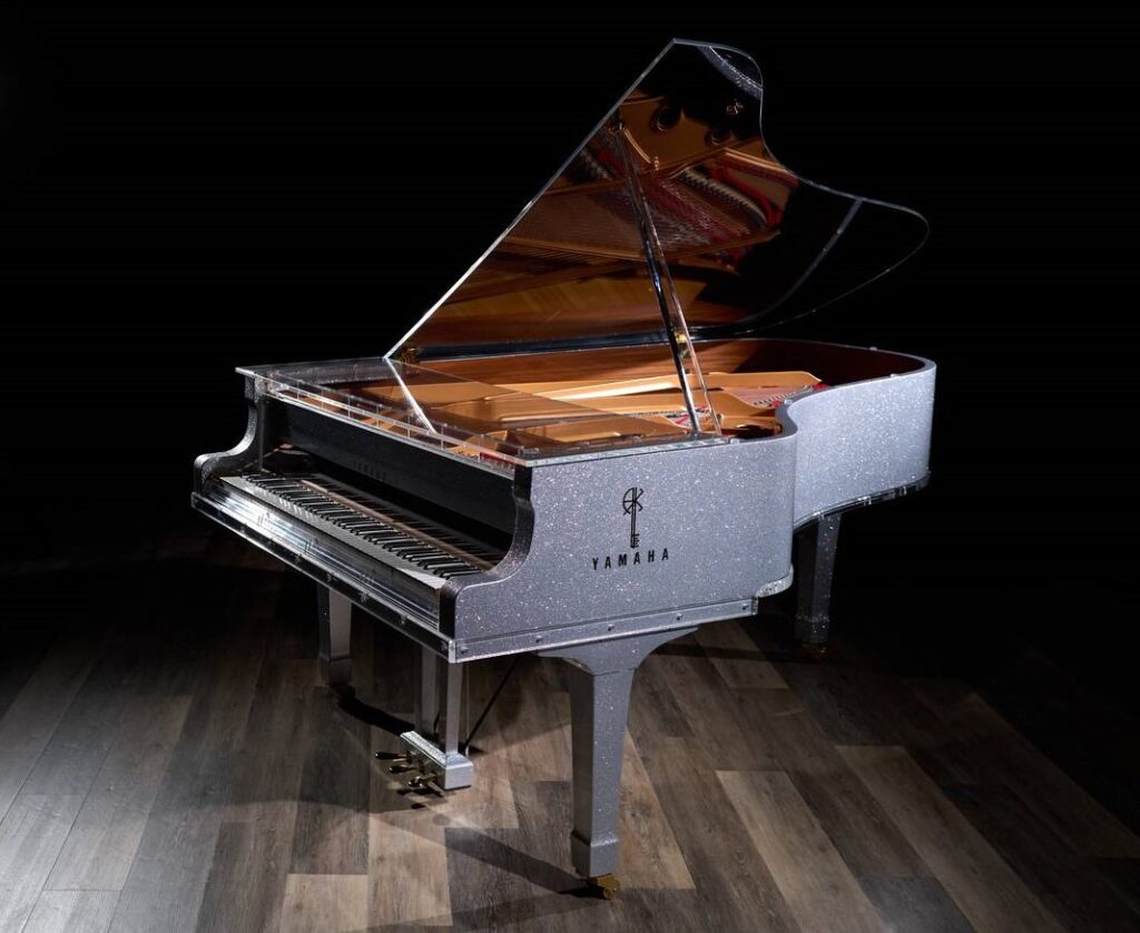 A grand piano with a silver metallic finish.