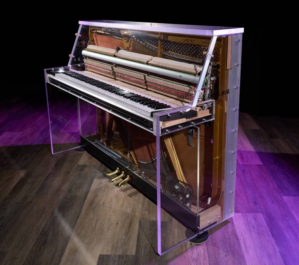 An upright piano in a clear casing.