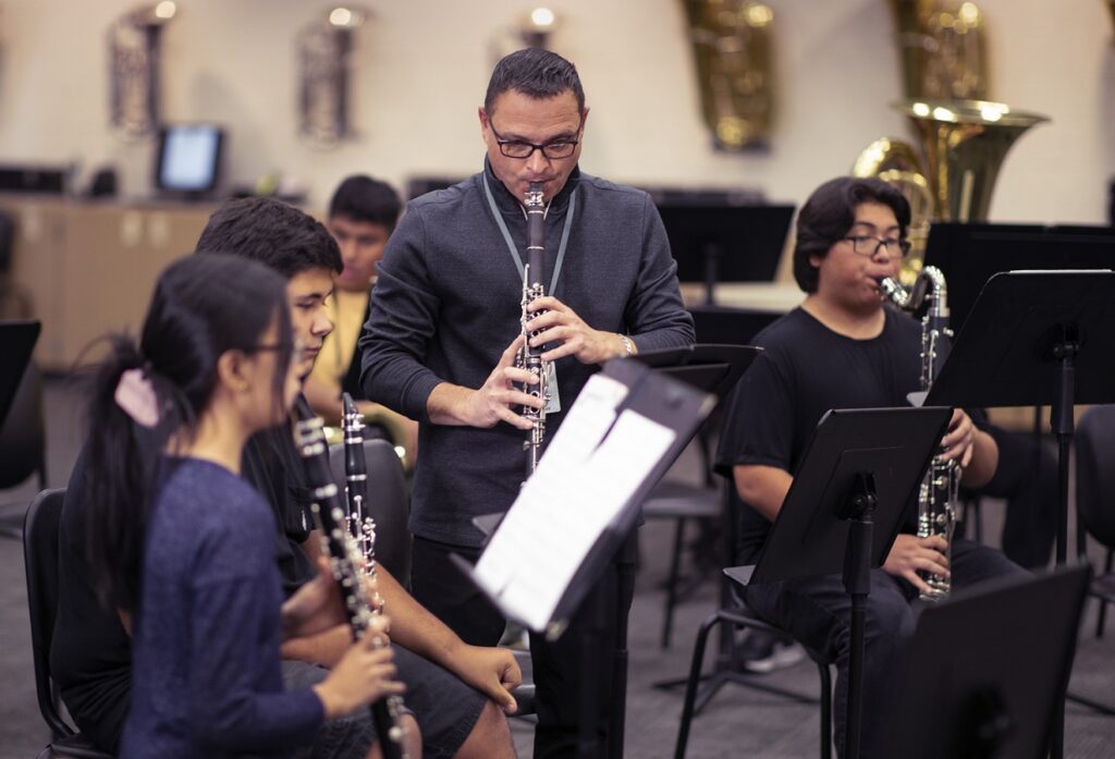 music educator playing clarinet with winds section