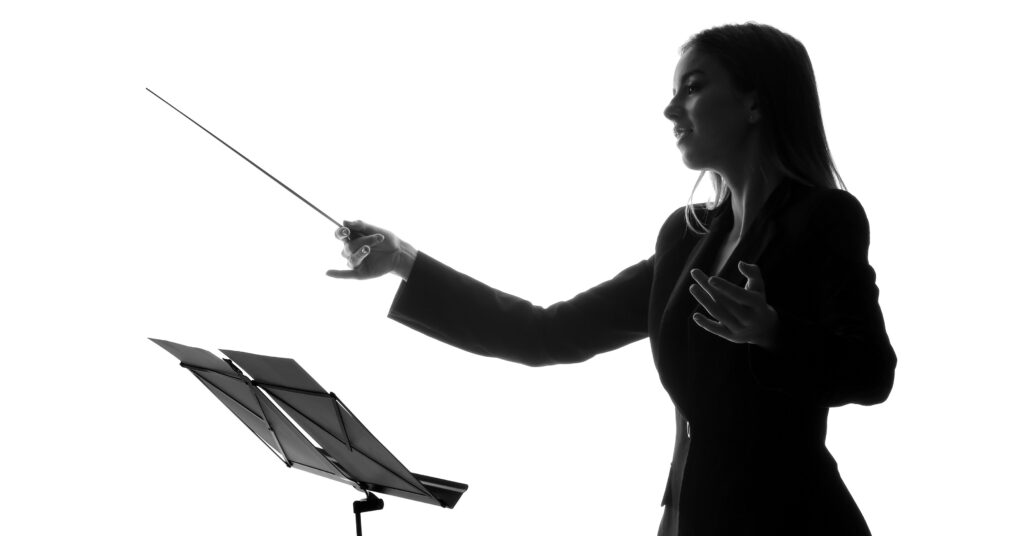 black and white photo of female conductor at podium